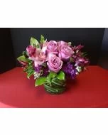 low arrangement with purple flowers, purple roses, orchids, alstromeria and stock